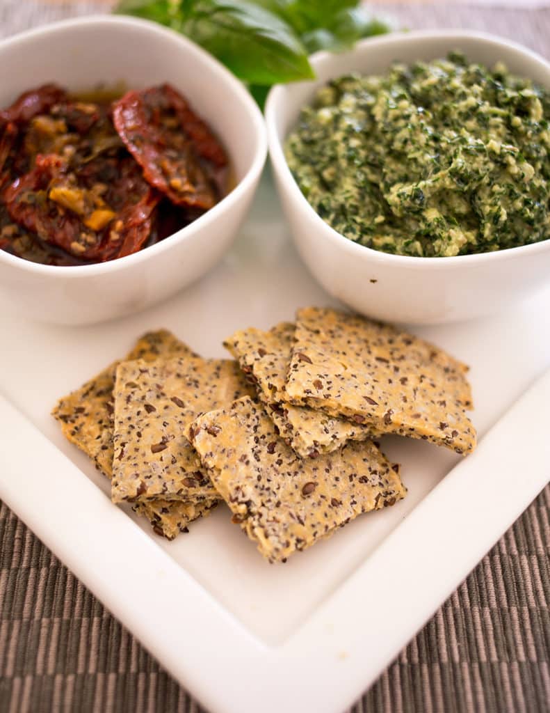 Gluten-Free crackers on platter with some pesto and sundried tomatoes