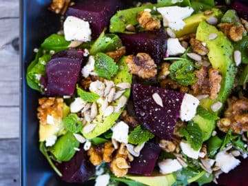 Close up of beetroot, avocado and quinoa salad on wooden background.