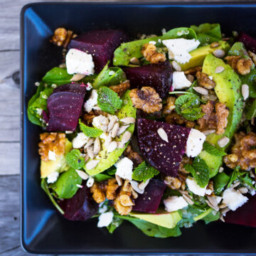 Close up of beetroot, avocado and quinoa salad on wooden background.