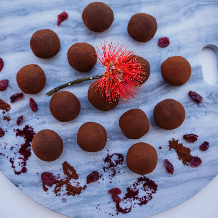 Chocolate cranberry truffles on marble background.