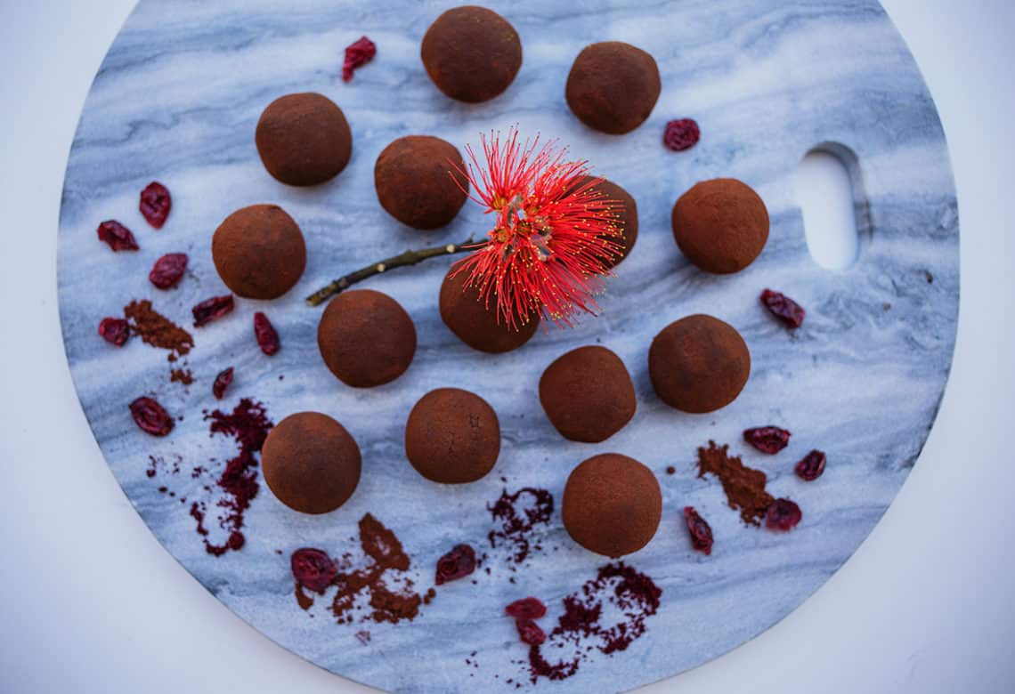 Chocolate cranberry truffles on marble background.