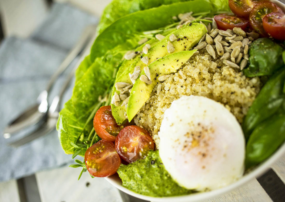 quinoa breakfast bowl with poached egg, avocado & pesto