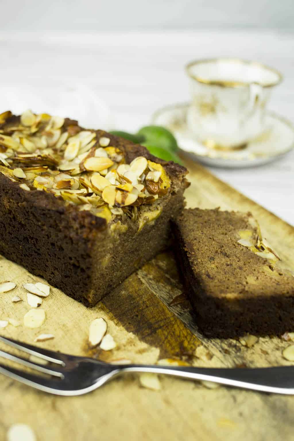 Feijoa and Banana Bread with slice cut and cup of tea on chopping board with fork