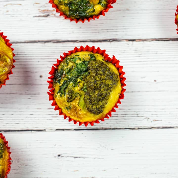 Healthy veggie egg muffins with broccoli, spinach, tomatoes and pesto, a healthy and tasty paleo breakfast or snack.