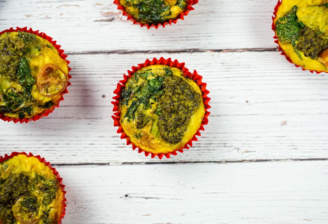 Healthy veggie egg muffins with broccoli, spinach, tomatoes and pesto, a healthy and tasty paleo breakfast or snack.