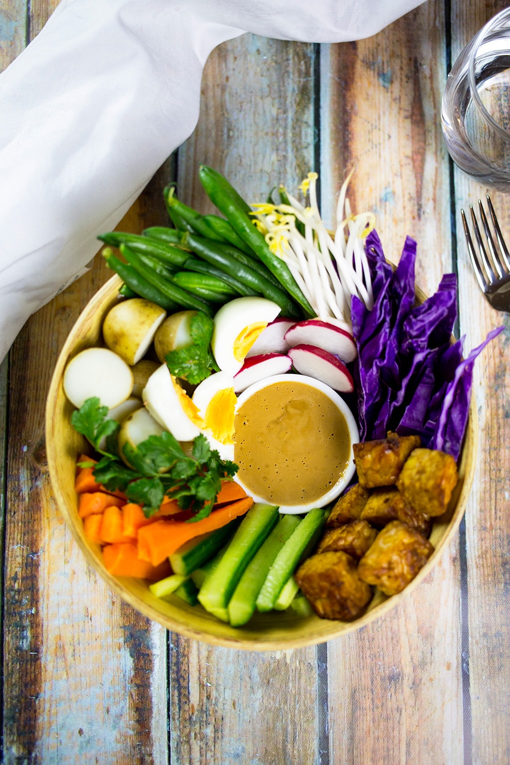 Gado Gado Indonesian Salad with white cloth and water to the side.