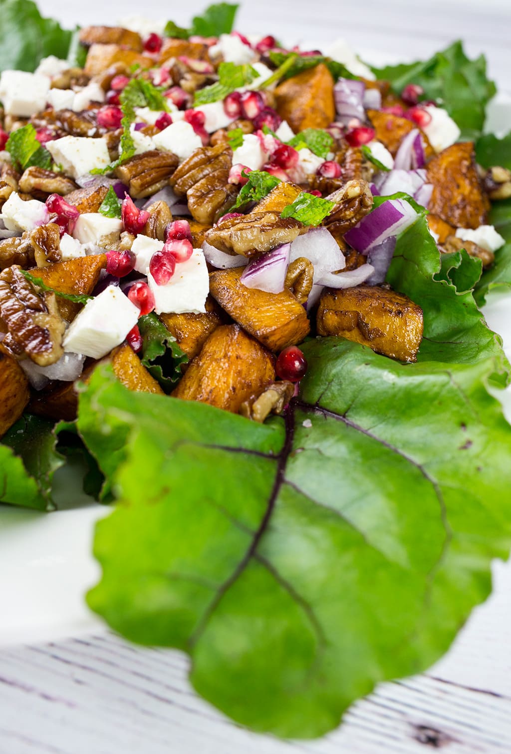 Close up of Sweet Potato Salad- Vertical photo with big green salad green at front of photo