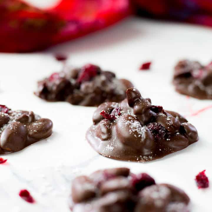 Chocolate almond clusters on white background.