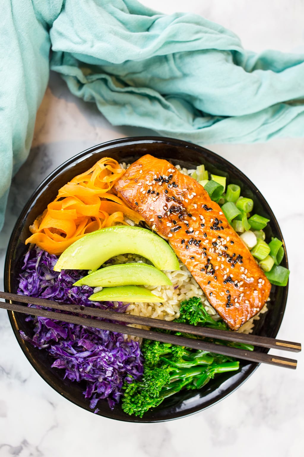 Teriyaki Salmon Bowl Birds Eye View in black bowl with green cloth in the background.