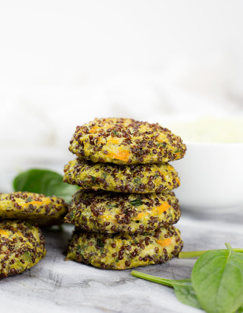 Vertical photo of baked quinoa veggie patties, 4 stacked showing them up close.