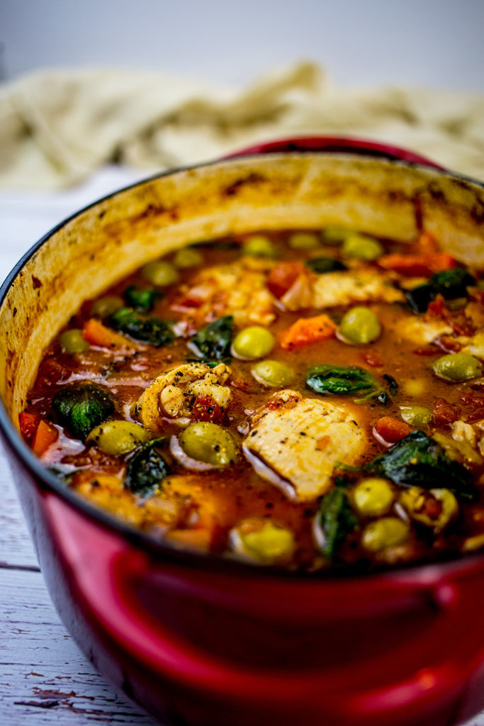 Close up of Spanish Chicken Stew with beige cloth in the background.