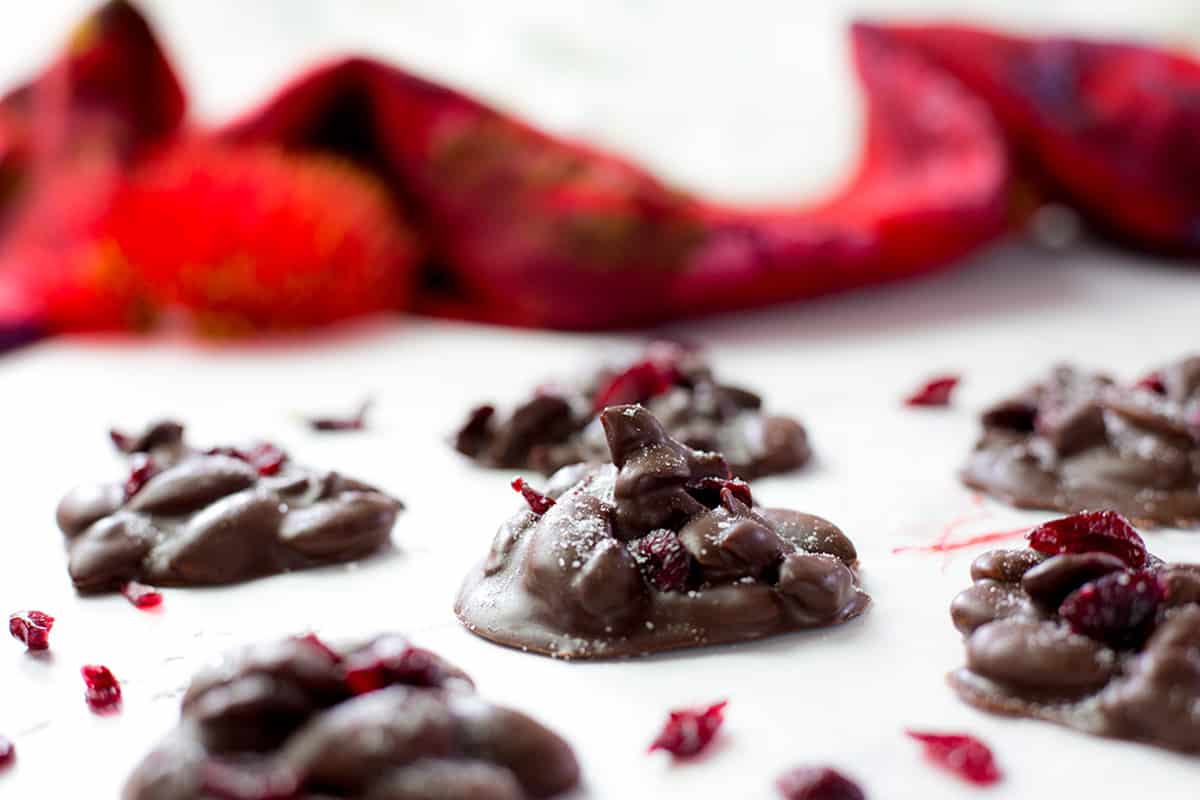 Chocolate almond clusters with red cloth in background.