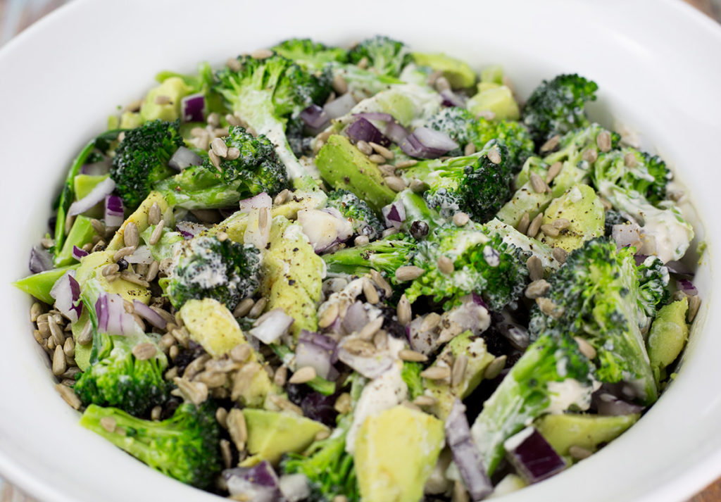 Birdseye view of healthy Broccoli Salad with Creamy Cashew Dressing mixed through it in a white bowl.