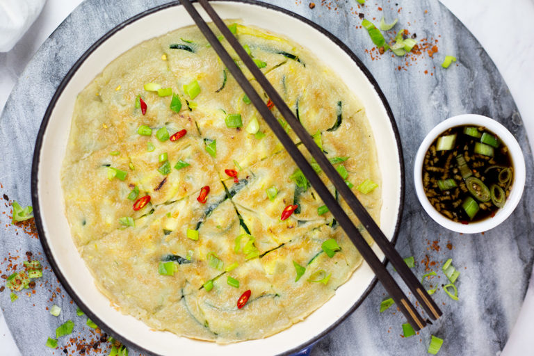 Paleo Zucchini Pancakes (Hobakjeon) with a sweet and sour dipping sauce. You need to try these! These Korean inspired savoury pancakes are the perfect mix of light, cripsy and tasty. Chock full of nutritious zucchini they are paired with a sweet and sour dipping sauce that will be a sensation for your taste buds. Paleo, grain free and gluten free.#paleorecipes #pancakes #koreanfood #asianfood #glutenfreerecipes #grainfree #paleobreakfast
