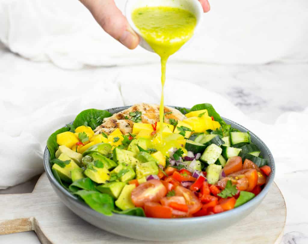 Chicken Mango Salad with Mango Cilantro Dressing pouring over it