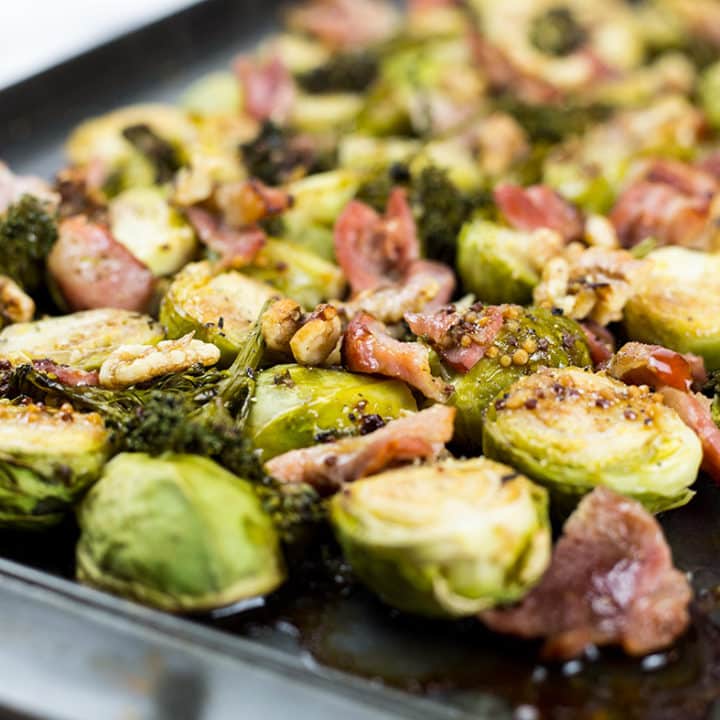 Brussels sprouts on baking tray with bacon, broccolini and walnuts.