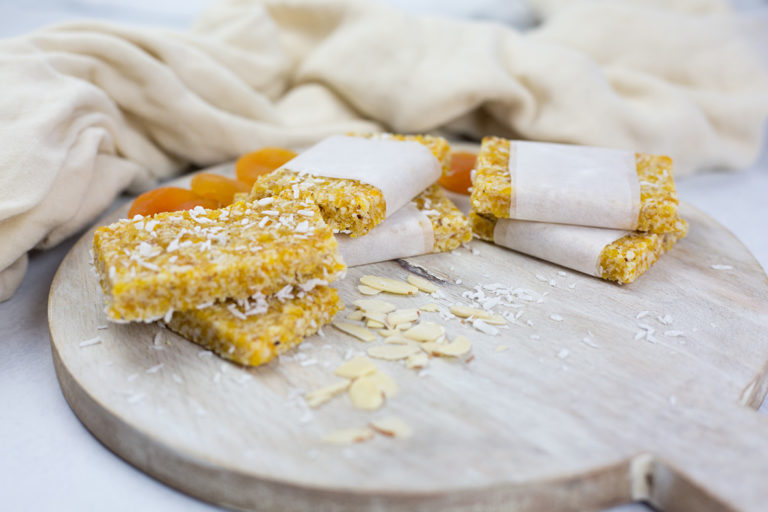 Apricot slice on board with cloth behind.