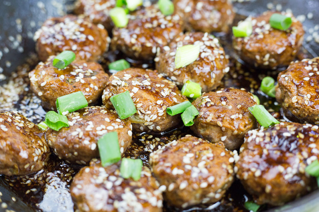 Close up of Asian style meatballs cooking in pan