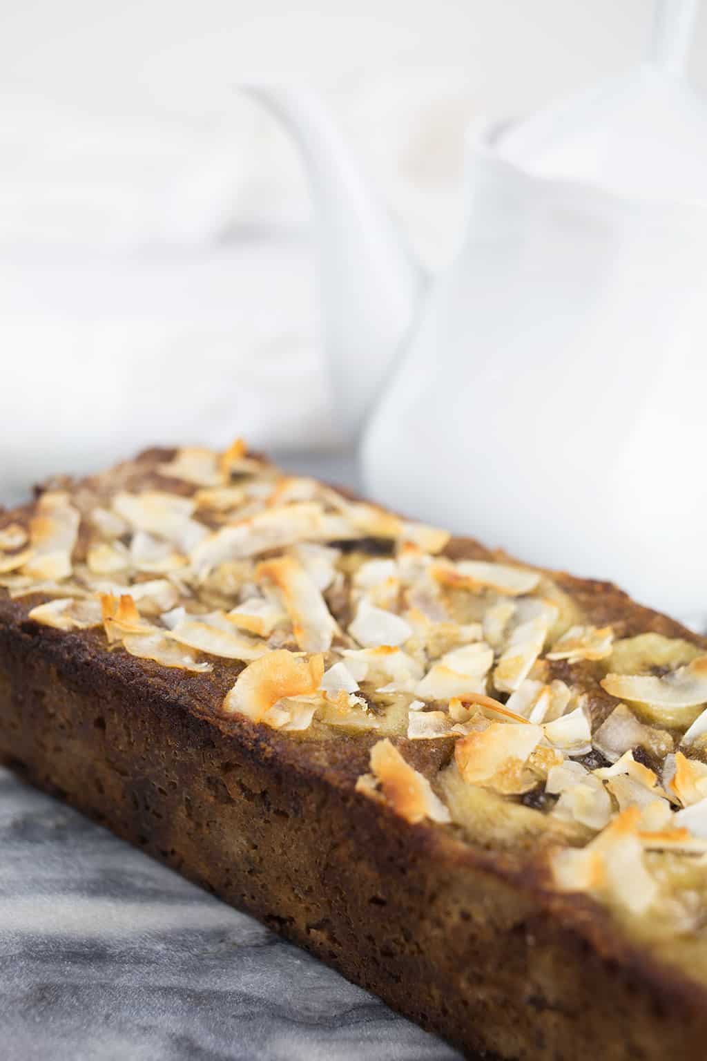 Top of coconut banana bread showing the shaved coconut and sliced bananas