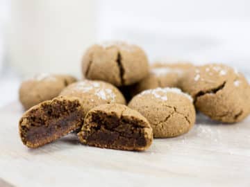 Ginger molasses cookies on board with one cute open.