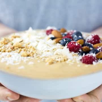 Peach Smoothie Bowl being held by a ladies hands.