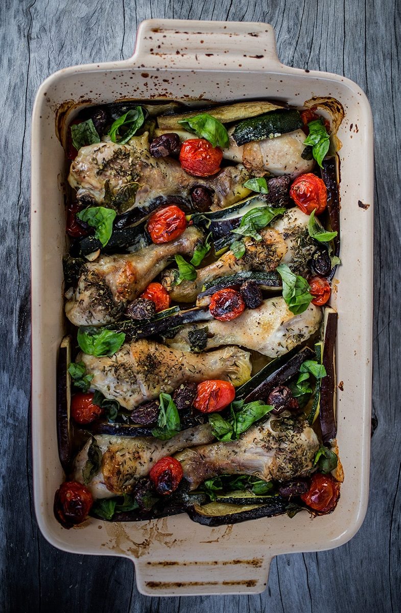 Mediterranean Chicken Bake in baking dish on wooden background.