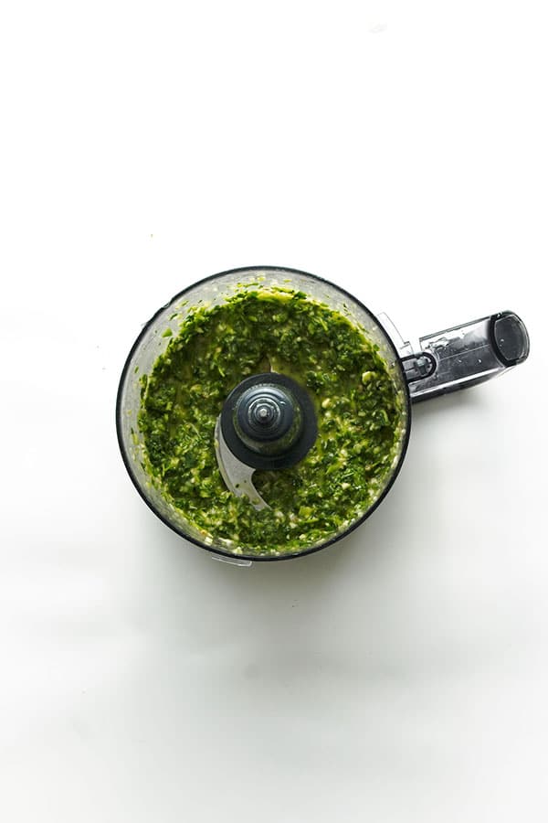 Ingredients for chimichurri blended in food processor.