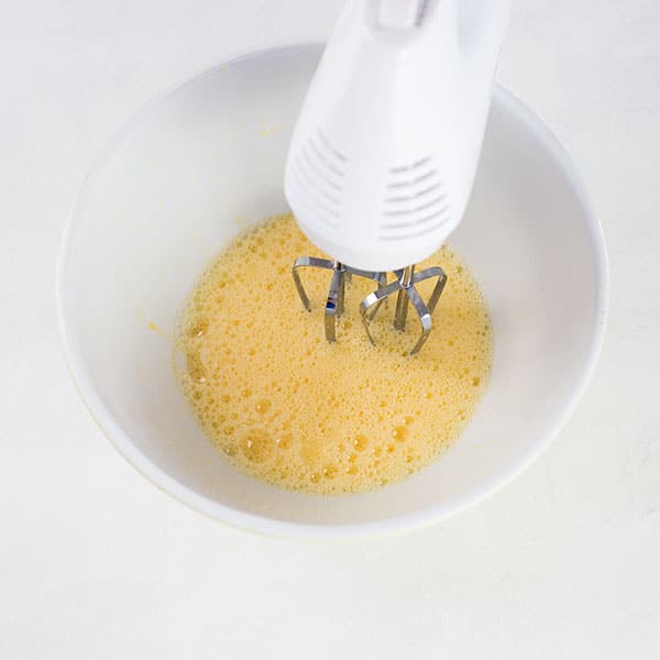 Whisking eggs in a white bowl.