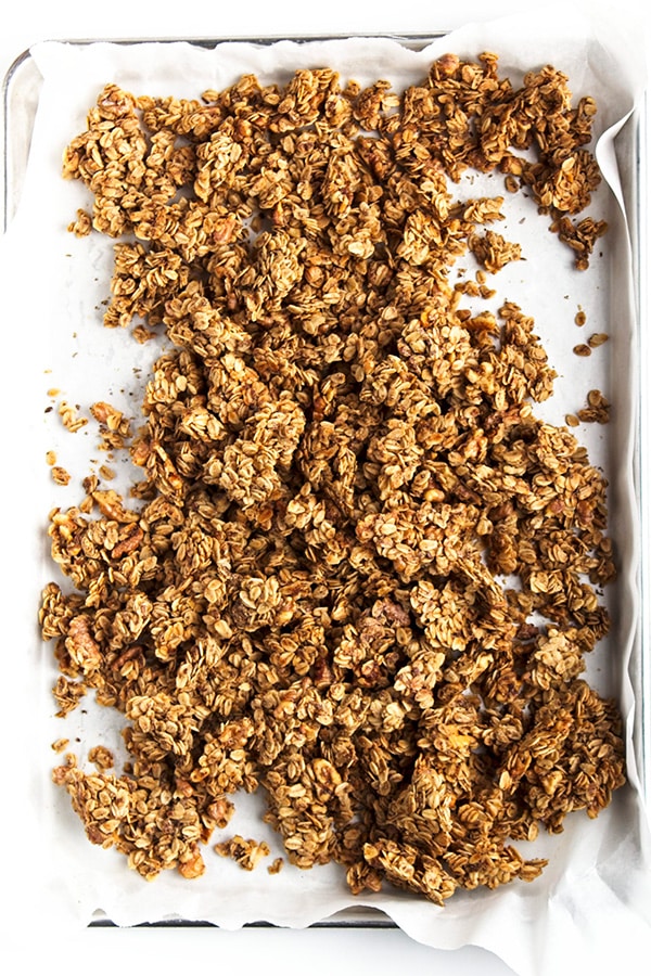Maple walnut granola out of oven broken into clusters on tray.