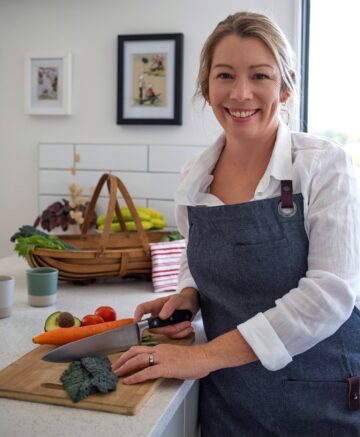 Hope Pearce Naturopath chopping vegetables on chopping board in kitchen.