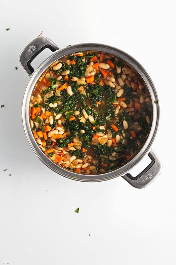 Kale and white bean soup in pot.