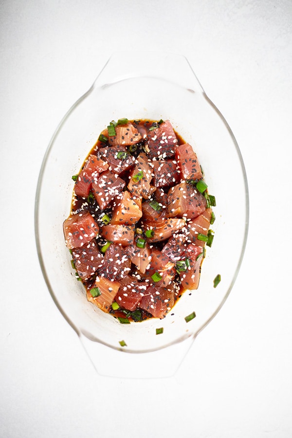 Tuna marinating in glass bowl.