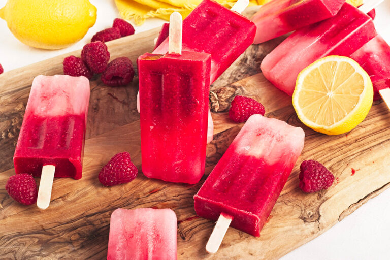 Raspberry Lemonade Popsilces on wooden board.