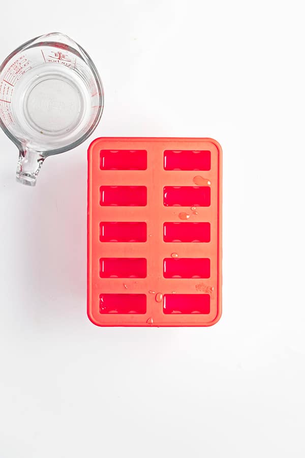 Lemonade mixture poured into popsicle moulds.