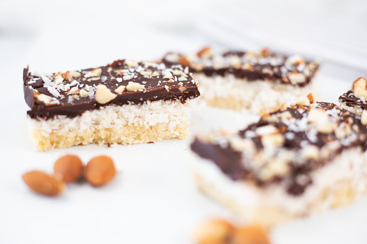 Close up of Chocolate Coconut Almond Bars with almonds in the front.