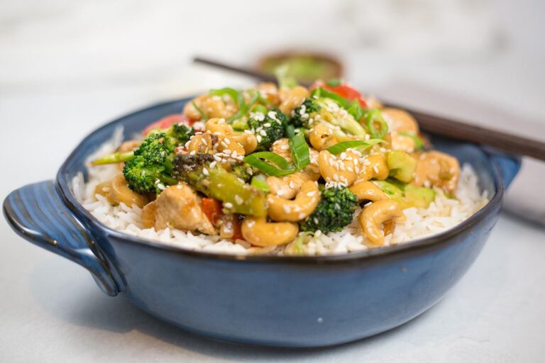 Chicken, cashew and broccoli stir-fry in blue bowl.