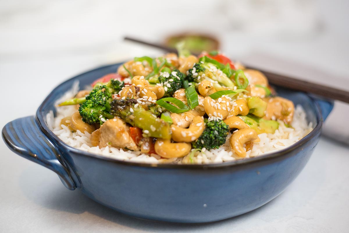 Chicken, cashew and broccoli stir-fry in blue bowl.