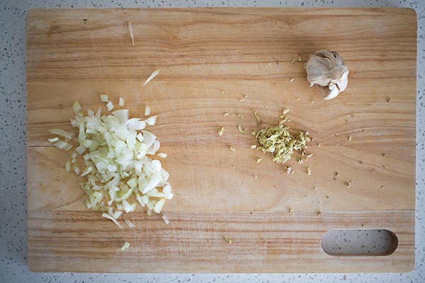 Onion, ginger and garlic on chopping board.